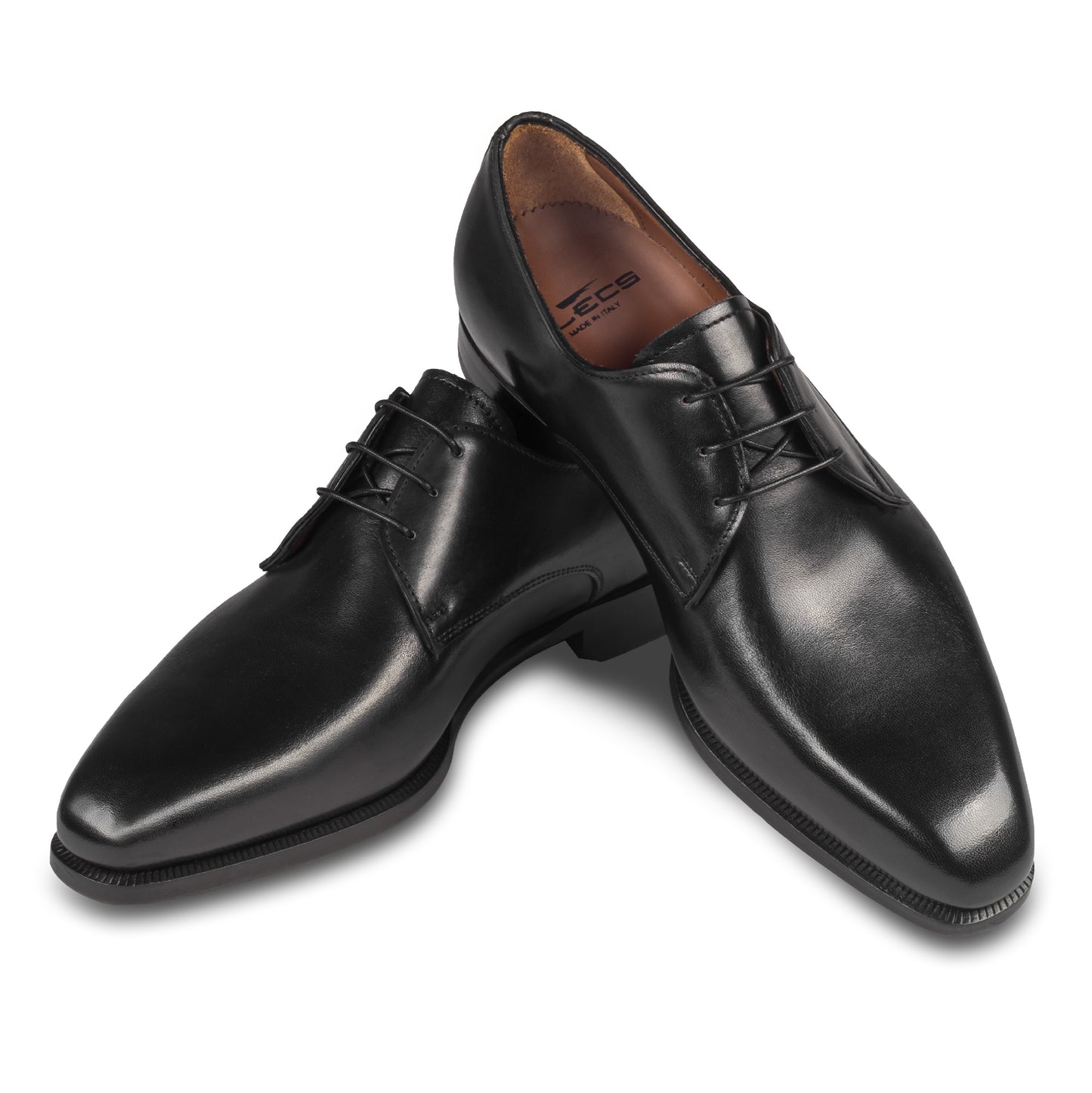 Anzugschuhe von Flecs, Plain Derby Schnürer in schwarz, durchgenäht. Paarweise Ansicht Schuhe überkreuzt aufgestellt. Bei Sisento.